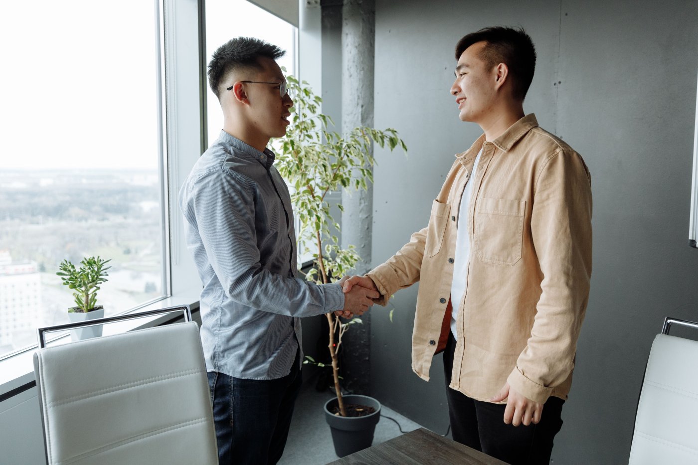 Two business partners shaking hands to confirm a referral agreement